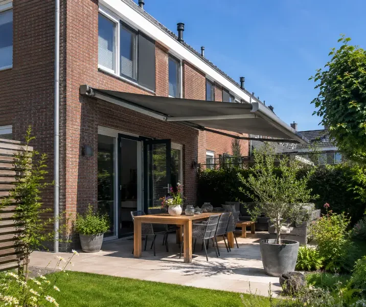 Een mooi hoekhuis met een knikarmscherm als buitenzonwering
